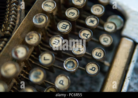 Nahaufnahme auf einem alten schmutzigen gebrochenen antike Schreibmaschine, Schlüssel mit kyrillischen Zeichen Buchstaben Stockfoto
