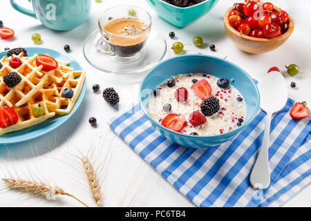 Foto von Wiener Waffeln, Haferflocken, Kaffee, frisch Himbeeren, Erdbeeren, Stachelbeeren Stockfoto