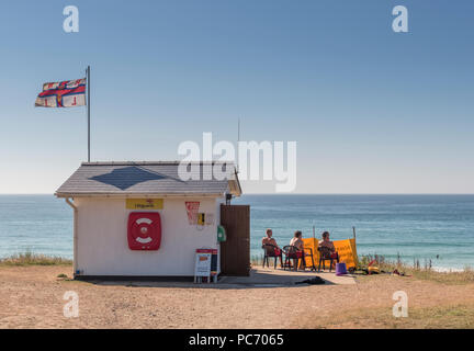 Rettungsschwimmer ein Auge auf den Strand vor ihrer Hütte an einem heißen und sonnigen Tag an gwithian Sands, North Cornwall Stockfoto