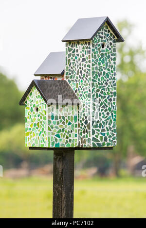 Nistkästen mit Mosaikfliesen auf Pole außerhalb Stockfoto