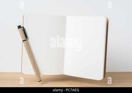 Designkonzept - Vorderansicht des schwebenden Kraftpapier Notebook und Desktop auf Holz und weißen Hintergrund für mockup Stockfoto
