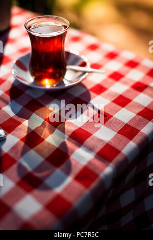 Türkischer Tee auf einem karierten Muster Tischdecke unter direkter Sonneneinstrahlung und Outdoor. Stockfoto