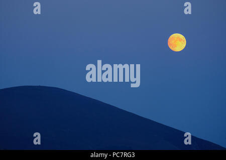 Einen gelben Vollmond über einen Berg in Snowdonia, WALES Stockfoto