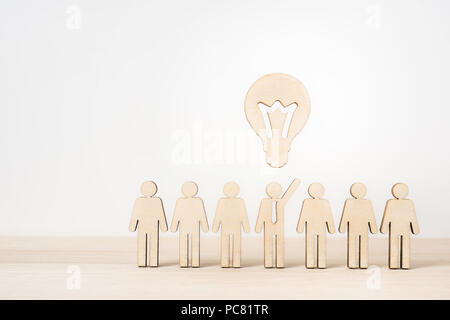 Business- und Designkonzept - Gruppe der Holz- Geschäftsmann Symbol mit Führung Konzept auf hölzernen Desktop und weißem Hintergrund Stockfoto