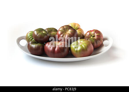 Organische heirloom Tomaten Brandywine auf Platte, isoliert auf weißem Stockfoto