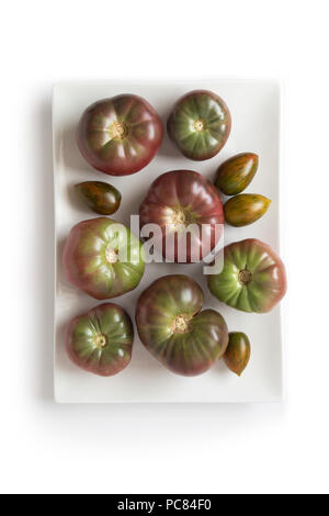 Organische heirloom Tomaten Brandywine auf einer weißen Platte, auf weissem, Ansicht von oben isoliert Stockfoto