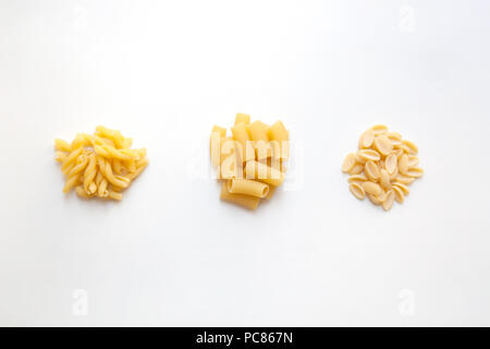 Drei haufen Rohstoff Weizen pasta mit verschiedenen Formen auf weißem Hintergrund Stockfoto