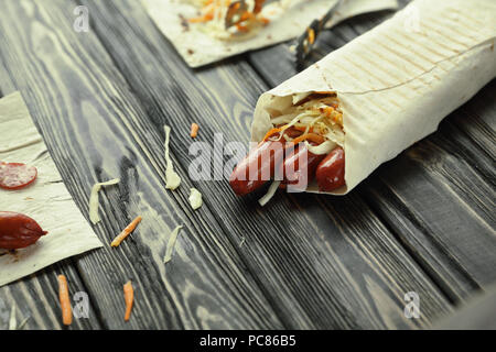 Geräucherte Wurst in pita Brot auf hölzernen Hintergrund Stockfoto