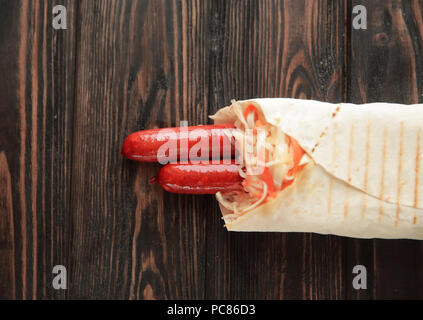 Ausschreibung Wurst in pita Brot auf hölzernen Hintergrund. Foto mit Kopie Raum Stockfoto