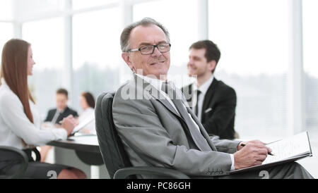 Nachdenklich reife Geschäftsmann in Anzug mit seinem Team hinter arbeiten Stockfoto