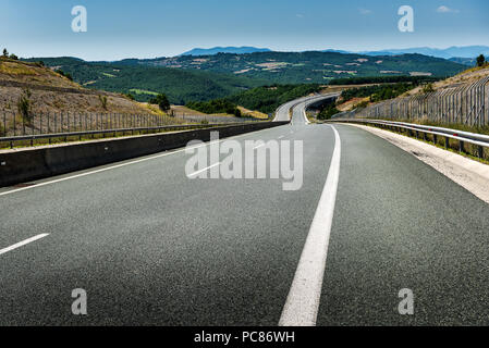 Autobahn oder Landstraße Wicklung zwischen Hügeln in einer ländlichen Landschaft Stockfoto