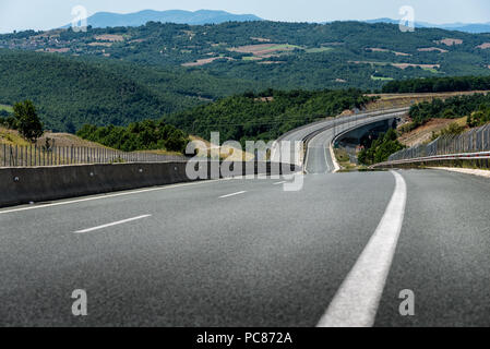 Autobahn oder Landstraße Wicklung zwischen Hügeln in einer ländlichen Landschaft Stockfoto