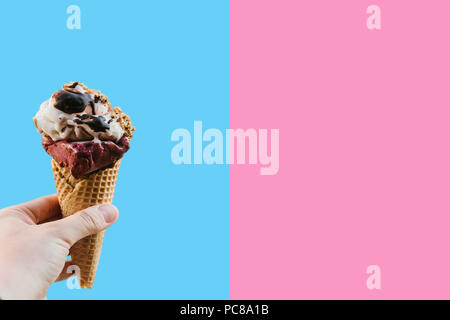 Eine weibliche Hand hält Eis auf einem farbigen Hintergrund. In der Nähe Platz für Text. Stockfoto