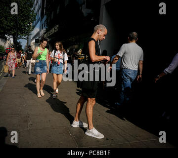 London, Großbritannien. 25. Juli, 2018. Menschen an einem heißen Tag in London gesehen. Credit: Ioannis Alexopoulos/Pacific Press/Alamy leben Nachrichten Stockfoto