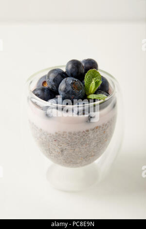 In der Nähe von Chia Samen Pudding mit Blaubeeren und Minze auf weiße Oberfläche Stockfoto