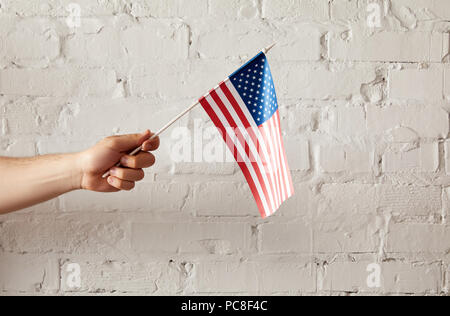 Teilansicht der Mann mit amerikanischen Fahnenmast gegen weiße Wand Stockfoto