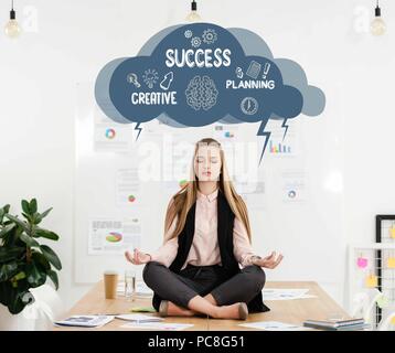 Ruhe Geschäftsfrau Meditation im Lotussitz auf Tisch im Büro, Cloud mit kreativen Erfolg planen Zeichen innen über dem Kopf Stockfoto