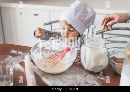 Kleines Kind in Chef hat Zubereitung Teig für Cookies Stockfoto