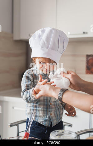 Mutter Reinigung Hände Kind in Koch hat nach dem Kochen Stockfoto