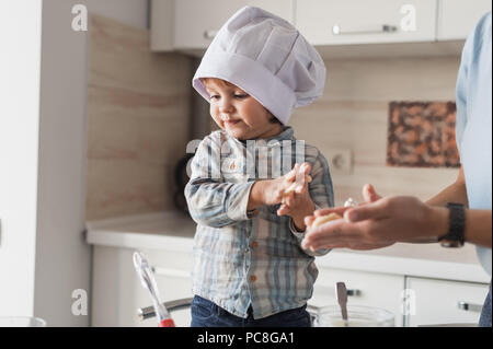 Mutter und Kind in Chef hat Cookies vorbereiten Stockfoto