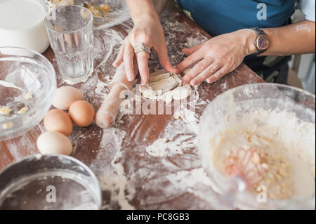 7/8 Schuß von Frau cookies Vorbereitung mit Schneidevorrichtung Stockfoto