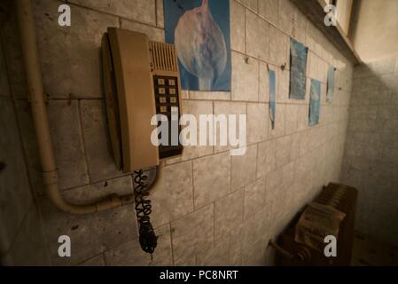 Old style Telefon an der Wand in einem verlassenen Gebäude montiert Stockfoto