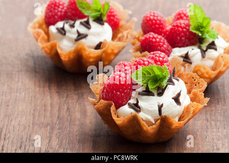 Brandy snap Körbe mit Eis und Beeren auf hölzernen Tisch Stockfoto
