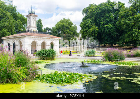 Die Kensington Gardens, die Italienischen Gärten mit Menschen genießen das warme Sommerwetter. Eine ornamentale Wasser Garten an der Nordseite des Hyde Park, in der Nähe von Stockfoto