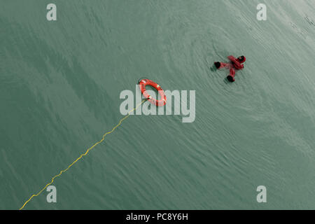 Crew Mitglied im Wasser, gekleidet in einem Survival suit bei Mann über Bord Bohren auf der Lindblad National Geographic Sea Bird. Stockfoto