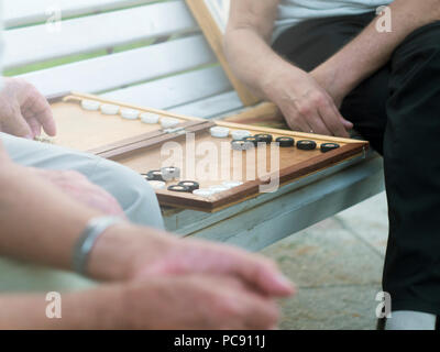 Zwei ältere Männer Backgammon spielen auf der Bank in der Straße in der Nähe von Stockfoto