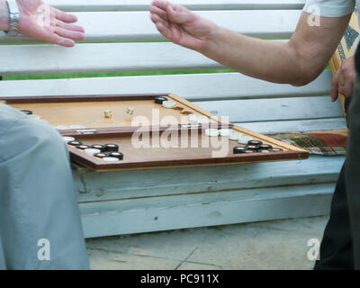 Zwei ältere Männer Backgammon spielen auf der Bank in der Straße in der Nähe von Stockfoto