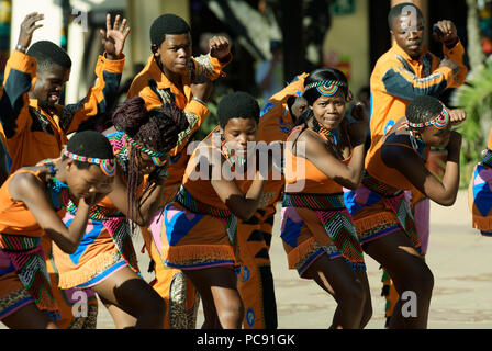 Ausdruck auf den Gesichtern der jungen männlichen und weiblichen Straßenkünstler, die sich während der traditionellen Zulu folk songs, Durban, Südafrika Stockfoto