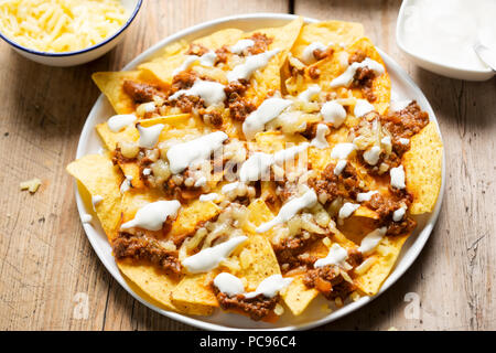 Chili Rindfleisch Nachos mit saurer Sahne und geriebener Käse Stockfoto