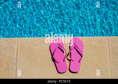 Rosa Damen flip flops neben dem Pool Stockfoto