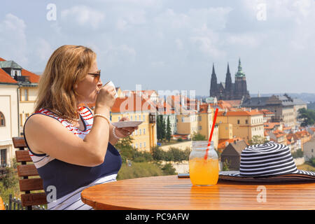 Kaffee mit Aussicht, Leute auf Cafe. Elegante kaukasischen Dame an Aussichtsterrasse sitzt, Getränke ihre Tasse Kaffee oder Tee und genießt Aussicht auf das Stadtbild der alten Stockfoto