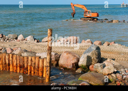 Baumaschinen auf dem Ufer, den Bau von Wellenbrechern, Küstenschutz Maßnahmen Stockfoto