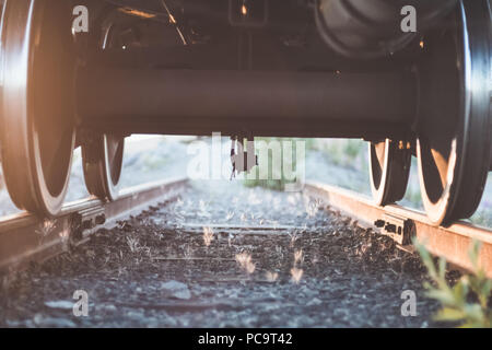 Ansicht unter dem Zug auf Rädern und felsigen Eisenbahn Stockfoto