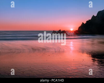 Lange Belichtung Fotografie der zerklüfteten Küste Felsen an der Pazifikküste an glühenden Sonnenuntergang. Eine Low Angle Shot bei Pfeiffer Big Sur, Kalifornien genommen Stockfoto