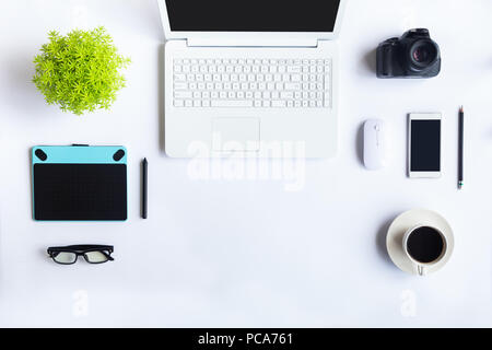 Weiß Schreibtisch im Büro mit Laptops, Smartphones und andere Arbeiten mit einer Tasse Kaffee. Ansicht von oben mit der Kopie Platz für die Eingabe des Textes. Designer Arbeitsbereich Stockfoto