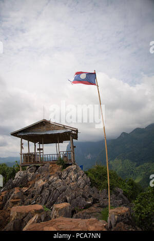 Kleine Bambushütte und Lao Flag am Aussichtspunkt über Nong Khiaw, Laos PDR. Stockfoto