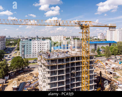 Vögel Auge Ansicht der Baustelle. Wohnhaus mit Gerüste und Kräne gegen den blauen Himmel Stockfoto