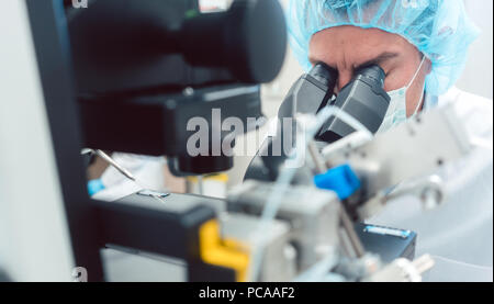 Arzt oder Wissenschaftler durch Mikroskop im Labor Stockfoto