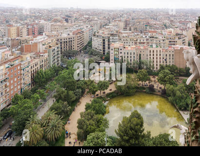 Blick auf Barcelona von der Sagrada Familia, der mit dem grünen Teich auf der Plaza de Gaudi (Gaudi) vor der Kirche und die Bäume Stockfoto