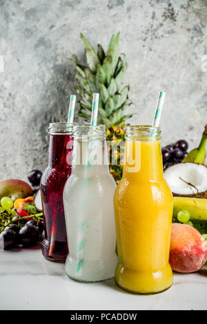 Verschiedene Fruchtsäfte Smoothies-konzept, Sommer Vitamine Diät, mit tropischen Früchten und Beeren auf hellem Hintergrund, Stockfoto