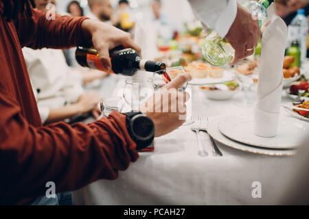 Ein Mann gießt Rotwein in ein Glas Stockfoto