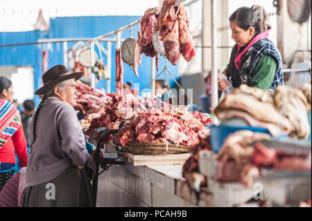 Tier Körperteile, eine örtliche Spezialität, die für den Verkauf auf einen Zähler angezeigt. Käufer und Verkäufer auf einen Jahrgang Südamerikanischen Markt. Cusco, Peru Stockfoto