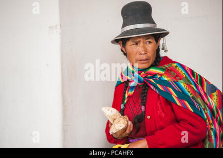 Lokale Frau in traditioneller Kleidung verkaufen verschiedene Gewürze und getrocknete Snacks, eine örtliche Spezialität. Vintage Südamerikanischen Markt. Cusco, Peru Stockfoto