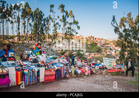 Lokale Frau mit Souvenirs, Spielzeug und Textilien. Bei einer Weinlese im Südamerikanischen Markt in der Nähe von Cusco, Peru angezeigt Stockfoto