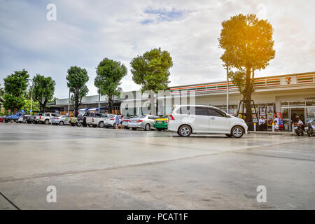 28. Juli 2018 Ratchaburi Thailand, Menschen fahren und geparkte Autos auf dem Parkplatz an der Ölpumpe vor der Reise Stockfoto