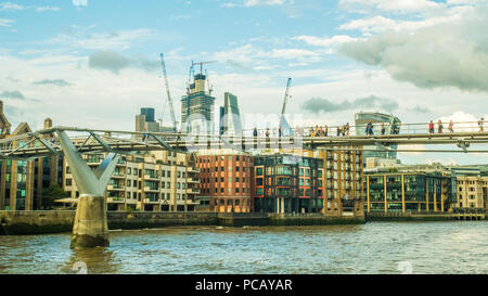 Millenium Bridge (Fußgängerbrücke) über die Themse mit dem 'Cheesegrater' & 'Walkie-Talkie' (rechts) Wolkenkratzer. Stockfoto